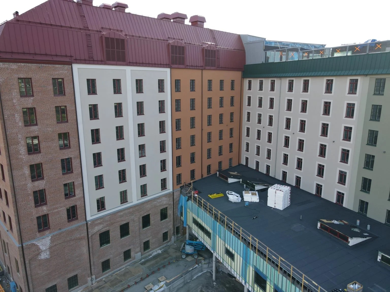 Fasader i rött och ljust tegel, vit puts och grön puts sida vid sida på Grand Curiosa Hotel